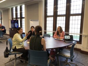 Four faculty sit at a table and discuss teaching at the Spring 2023 language spring showcase