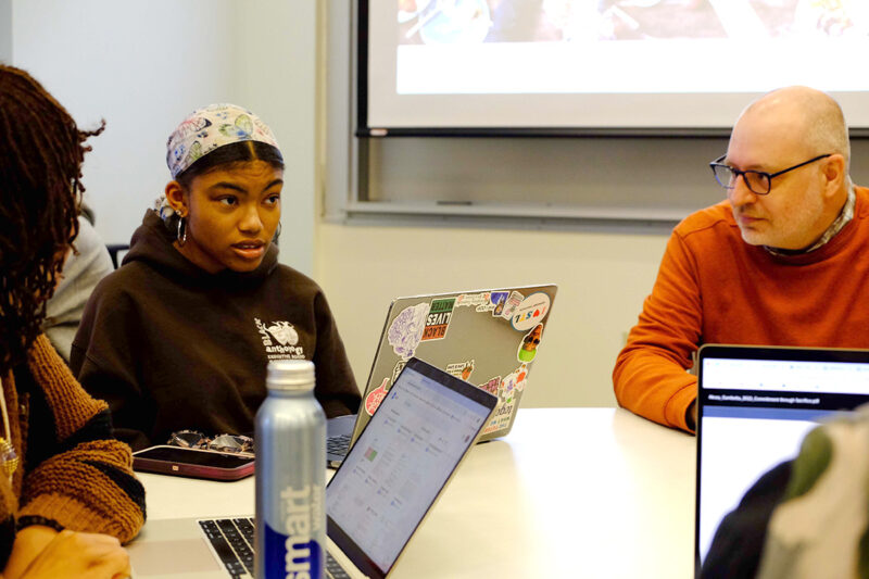 A CTL consultant speaking with students at a table