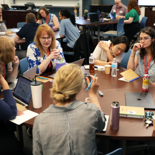 Group of faculty work together at a table