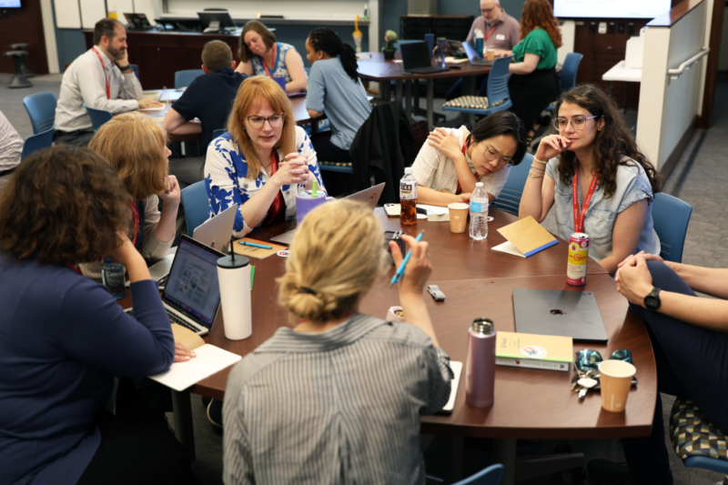Group of faculty work together at a table